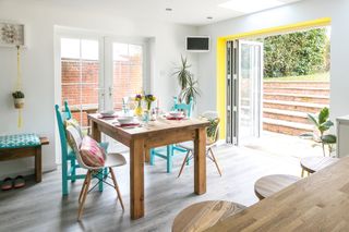Open-plan dining area with bi-fold doors leading to garden