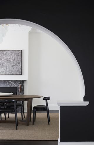 A living room with black painted arch