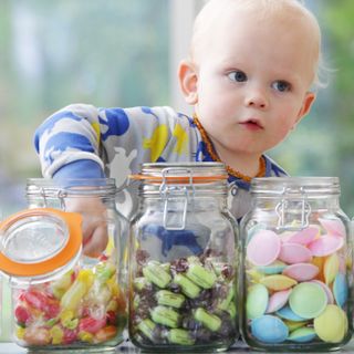 Child reaching into a sweet jar