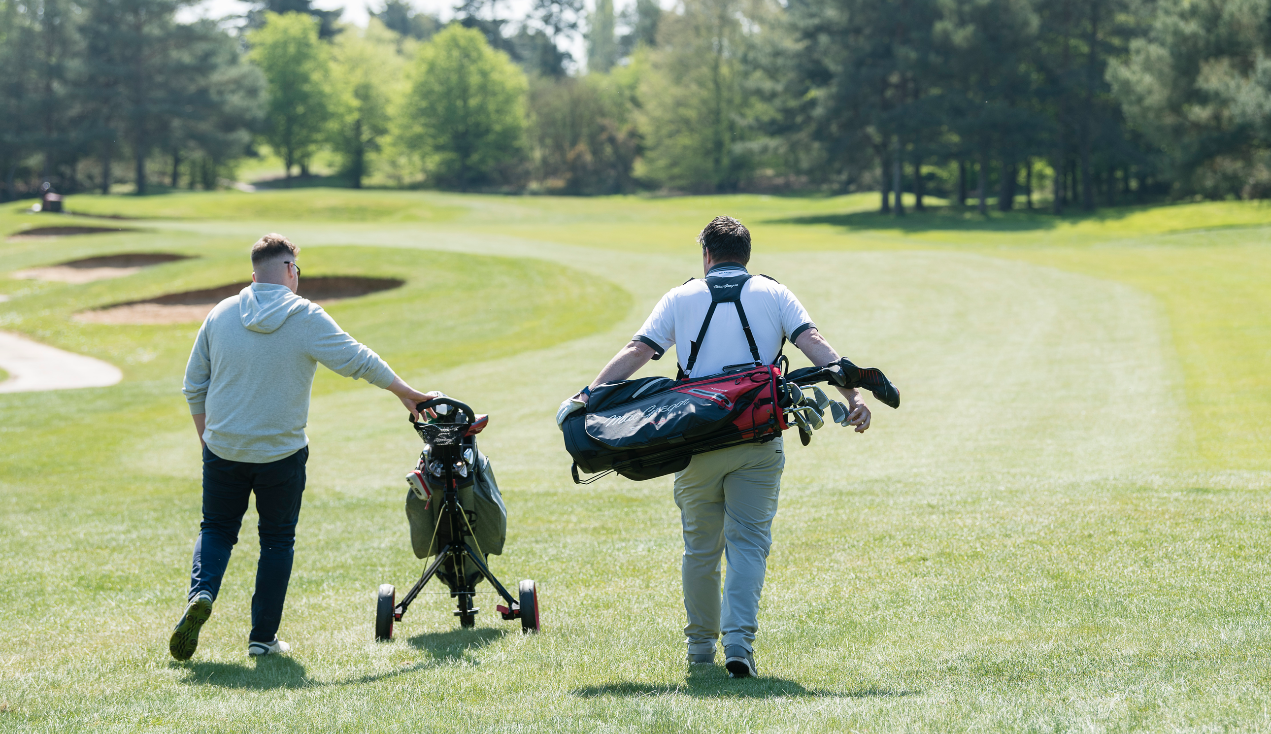 Two golfers walk down the fairway