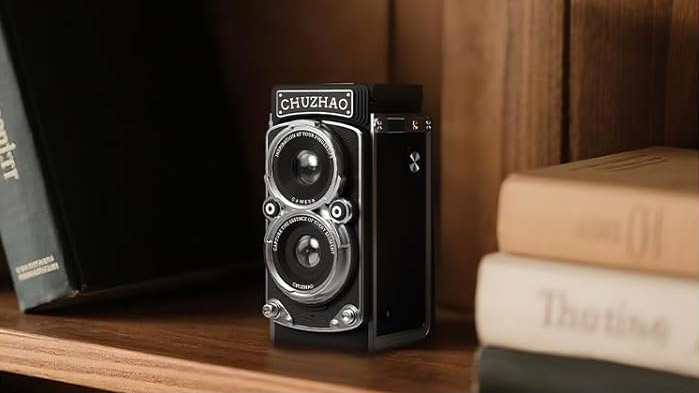 A lifestyle product picture of the CHUZHAO Retro TLR 12MP Digital Camera on a bookshelf as an ornament