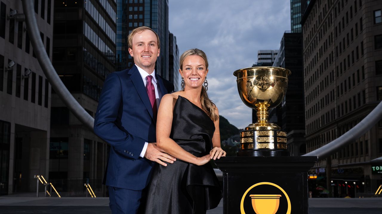 Russell Henley and his wife, Teil Duncan pose next to the Presidents Cup in 2024