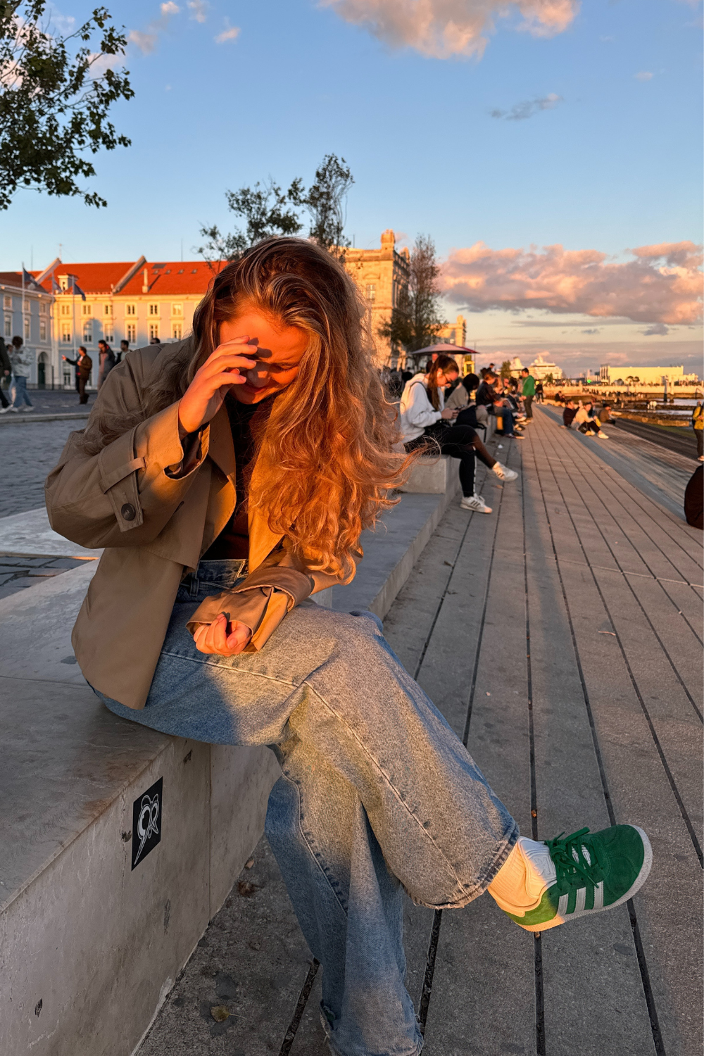 Lauren Cunningham wears green Adidas suede trainers, jeans and cropped trench coat