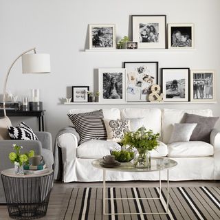 living room with white wall and grey and white sofa