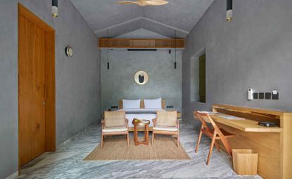 An image with a view of the guest room showing the bed and the desk 