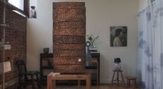 Installation view of a gallery focused on artisanal furniture, artworks, and sculptures, filled with one-off pieces in wood, ceramics, leather, and textile.