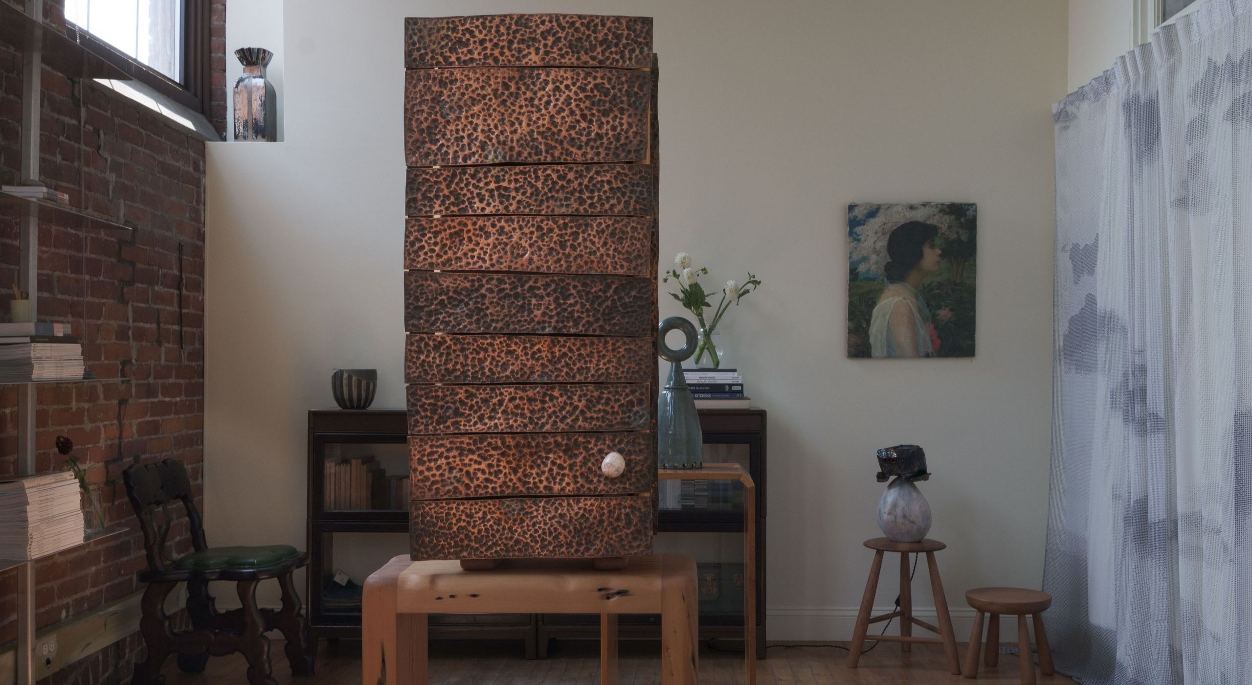 Installation view of a gallery focused on artisanal furniture, artworks, and sculptures, filled with one-off pieces in wood, ceramics, leather, and textile.