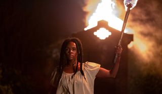 Antebellum Veronica marches with a torch in her hands