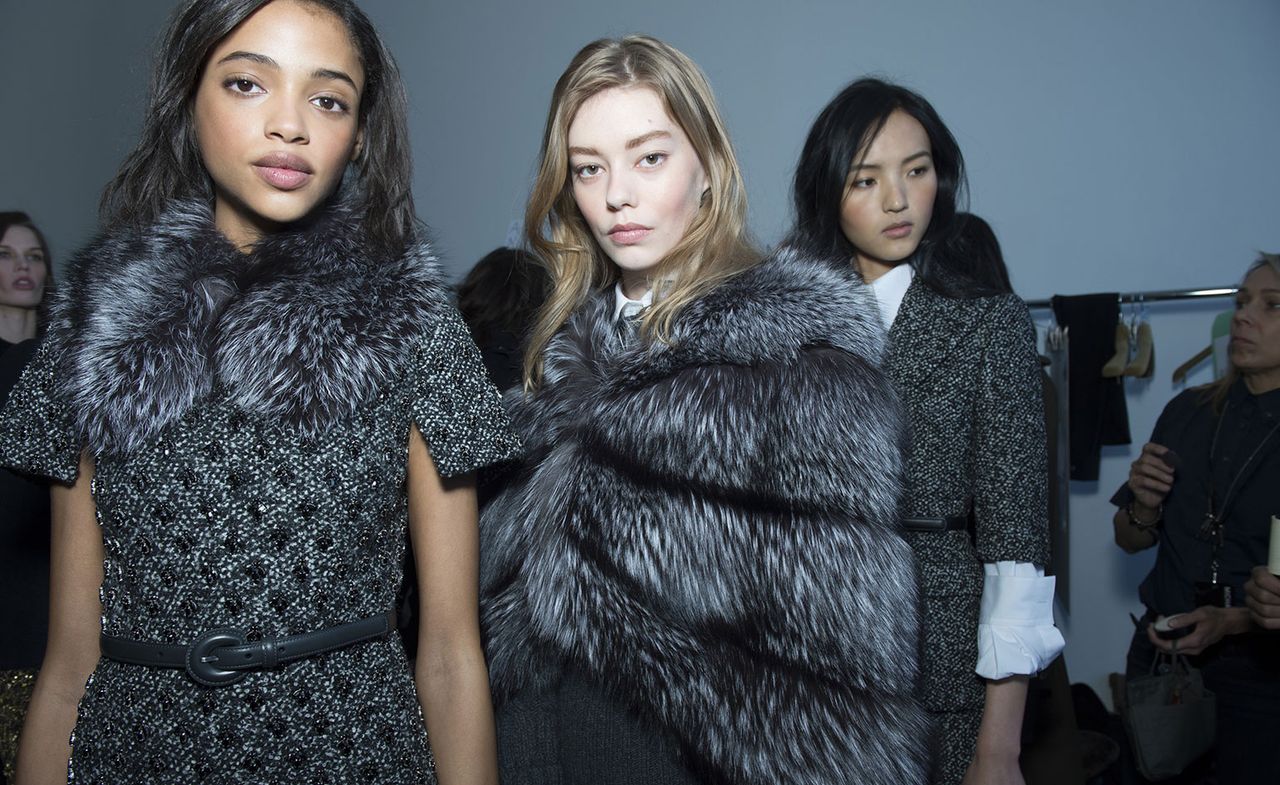 2 Models wearing grey and white winter dresses with fur accessories