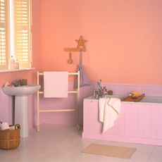 bathroom with peach wall and wash basin with bathtub