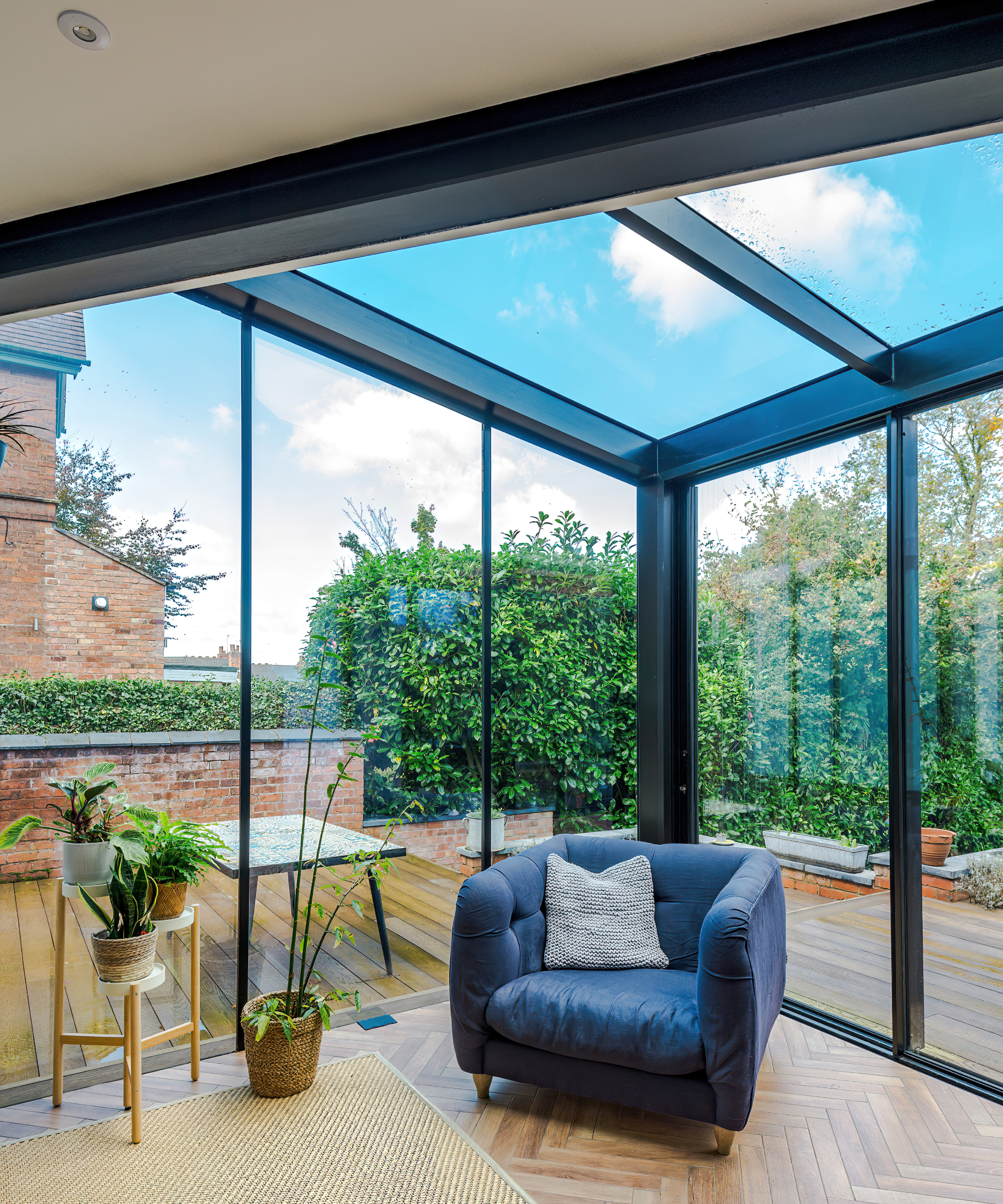 glazed corner of room with glass roof, floor to ceiling windows and sliding patio doors