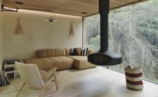 A cabin living room with suspended fireplace
