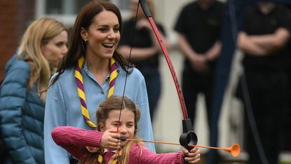 Princess Charlotte and Kate Middleton practice archery together, with Charlotte shooting a bow and arrow
