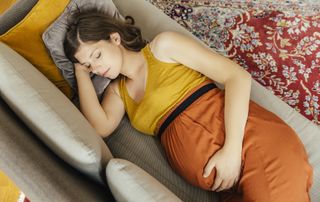 pregnant woman sleeping on sofa