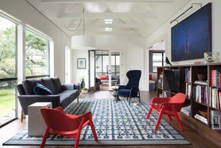 living room with blue patterned rug and red chairs