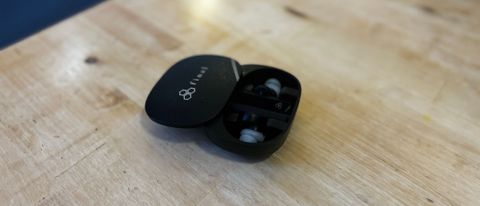 Final ZE8000 earbuds on a wooden table, the case open to reveal the buds inside
