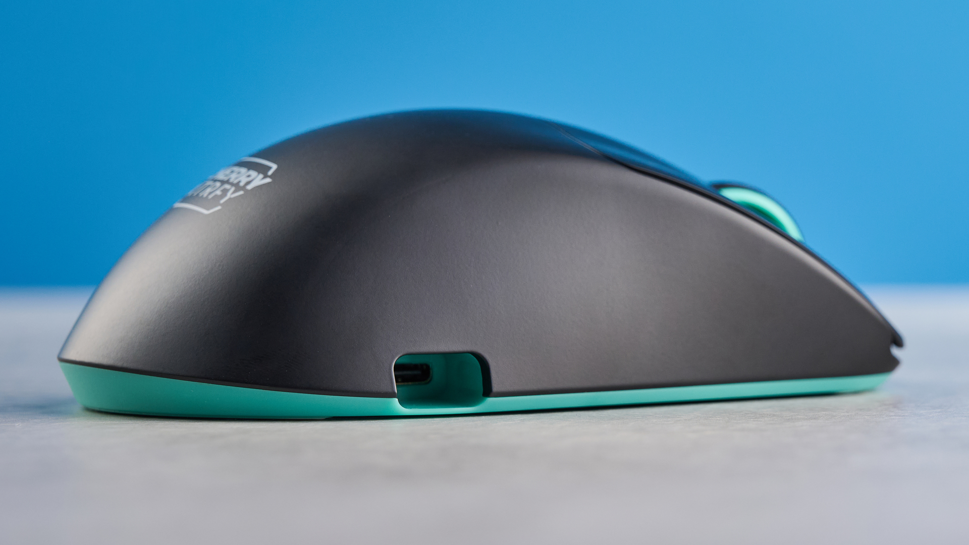 A black and teal Cherry XTRFY M64 Wireless gaming mouse