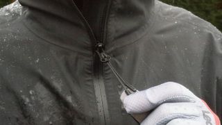 Hand pulling zip toggle of cycling jacket