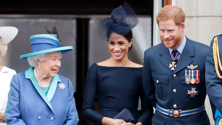 Queen Elizabeth II, Meghan, Duchess of Sussex and Prince Harry, Duke of Sussex watch a flypast to mark the centenary of the Royal Air Force from the balcony of Buckingham Palace on July 10, 2018 in London, England
