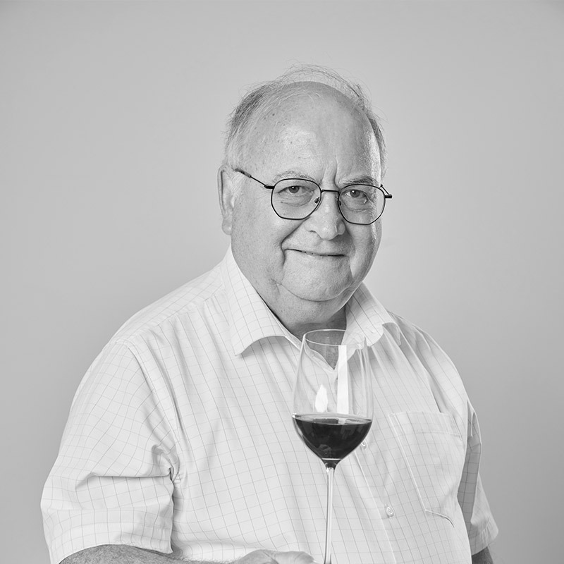 Photo of Michael Denton holding a glass of red wine