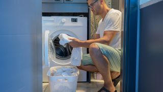 Washer-dryer combo mistakes - a man examining clothes out of the washer dryer