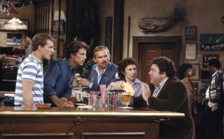 the cast of cheers standing over the bar