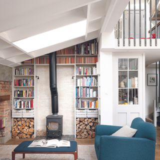 Living room with white walls, wood burner and built-in bookshelves.