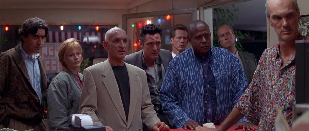 A group of people all looking at something off screen, with serious expressions on their face.