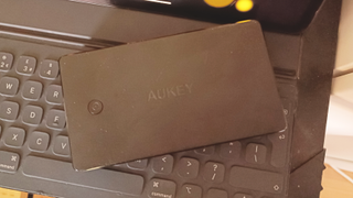 An Aukey power bank on an iPad keyboard