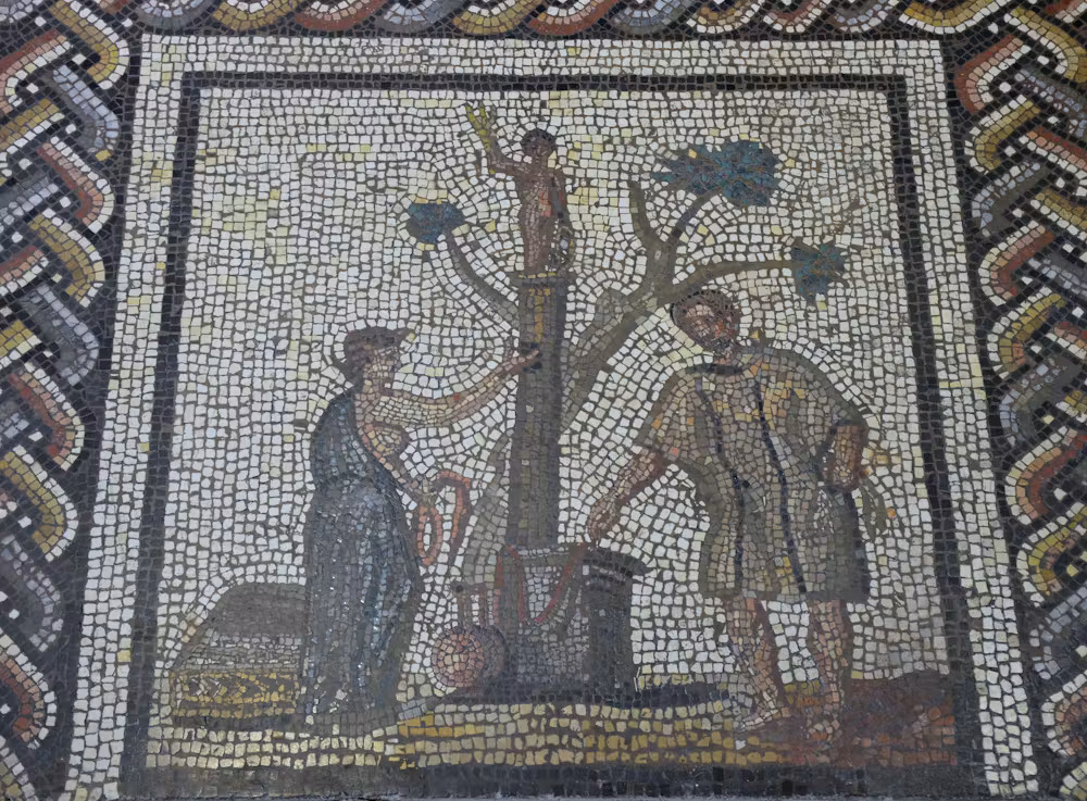 A close up of a mosaic with people around a tree.