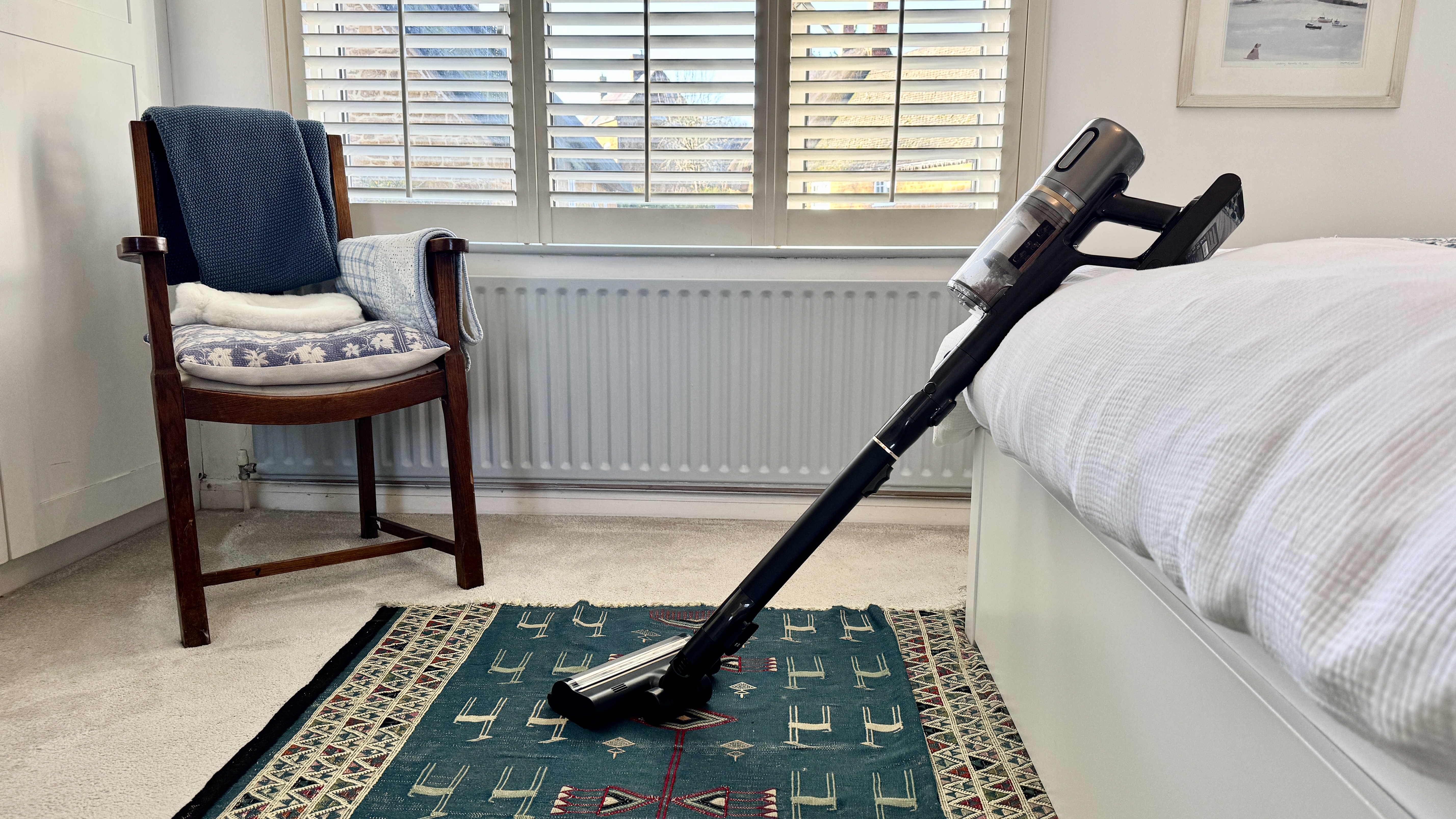 Dreame V20 Pro vacuum leaning against a bed