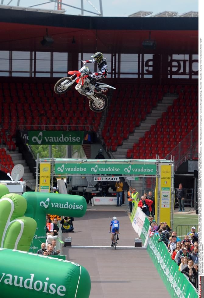 A Motocross rider jumps a rider on the entrance to the football stadium