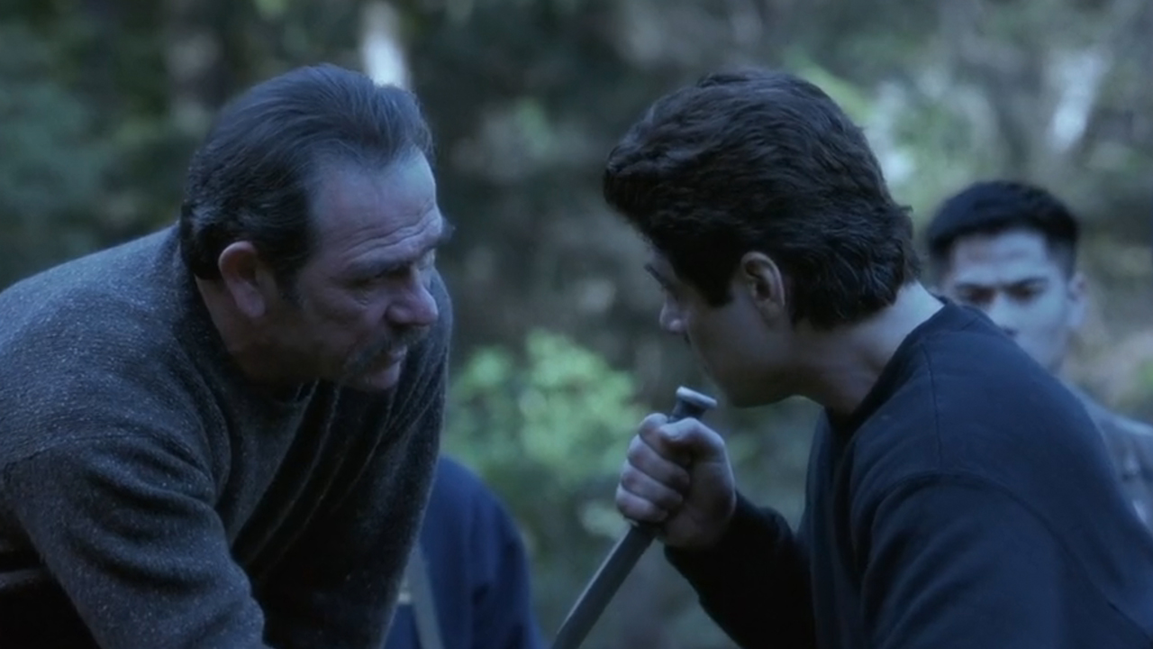 『ザ・ハンテッド』でナイフを持ったベニチオ・デル・トロを見つめるトミー・リー・ジョーンズ