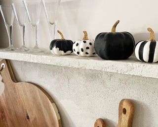 Black and white patterned painted pumpkins on a kitchen shelf