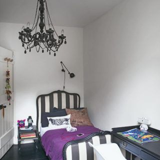 single bedroom with fun monochrome scheme with a striped bed and purple throw