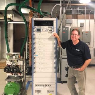 Gary Marifke, chief engineer for Milwaukee’s WVTV, poses with a five-kW “temporary” transmitter that will remain in operation until there’s time to “do things over” to comply with the station’s CP.