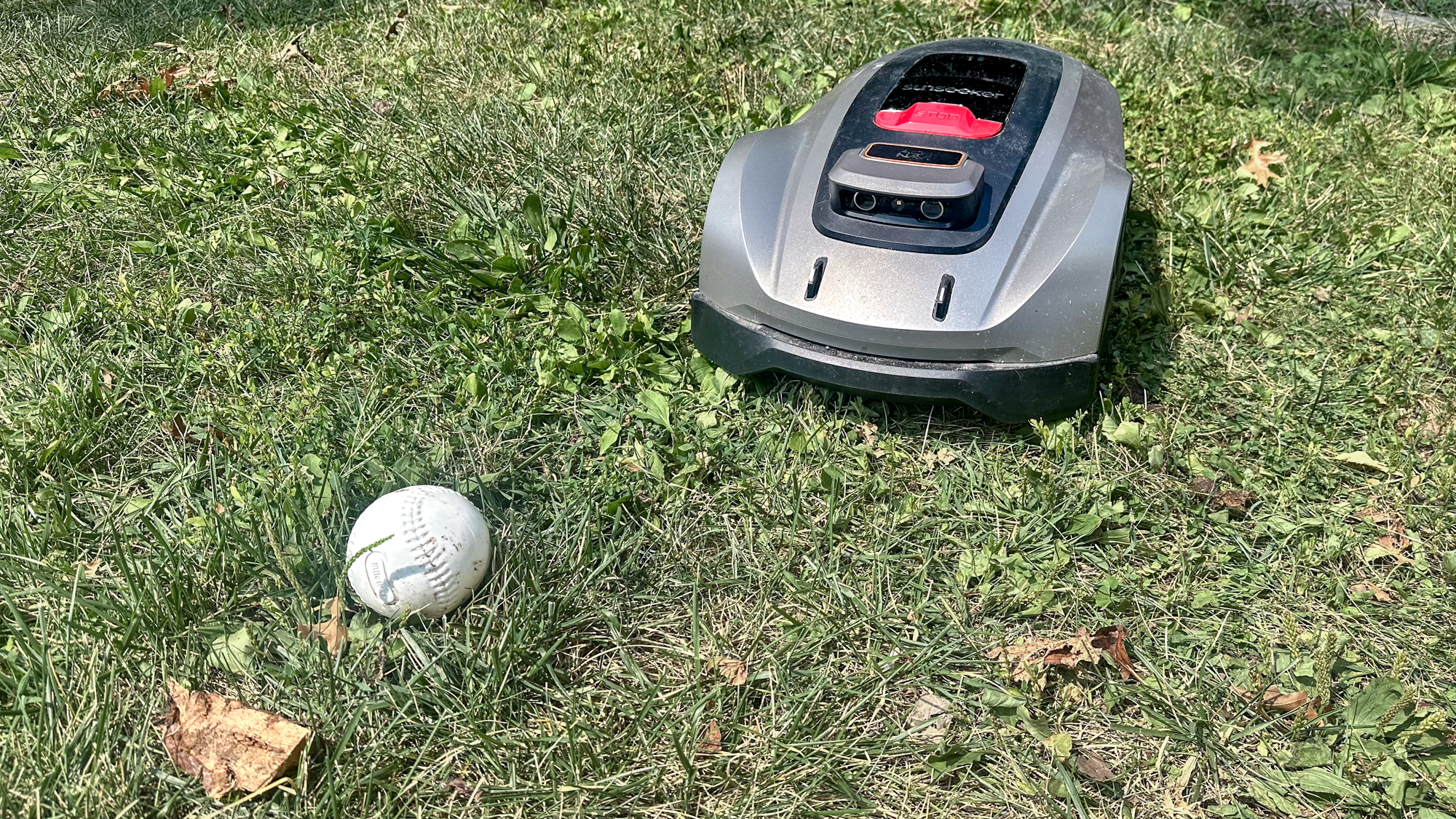 Sunseeker X3 Plus robot lawnmower avoiding a softball