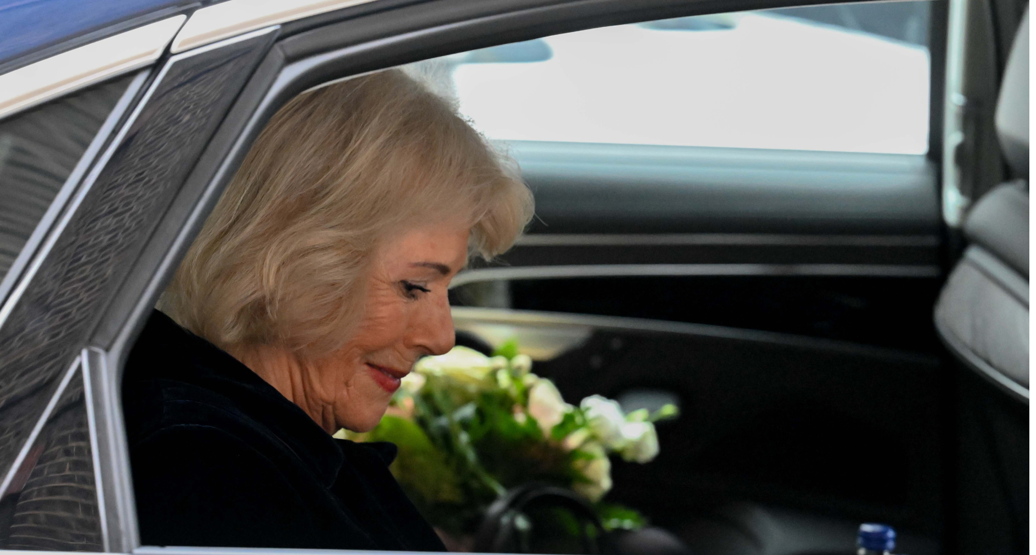 Queen Camilla riding in a car wearing black