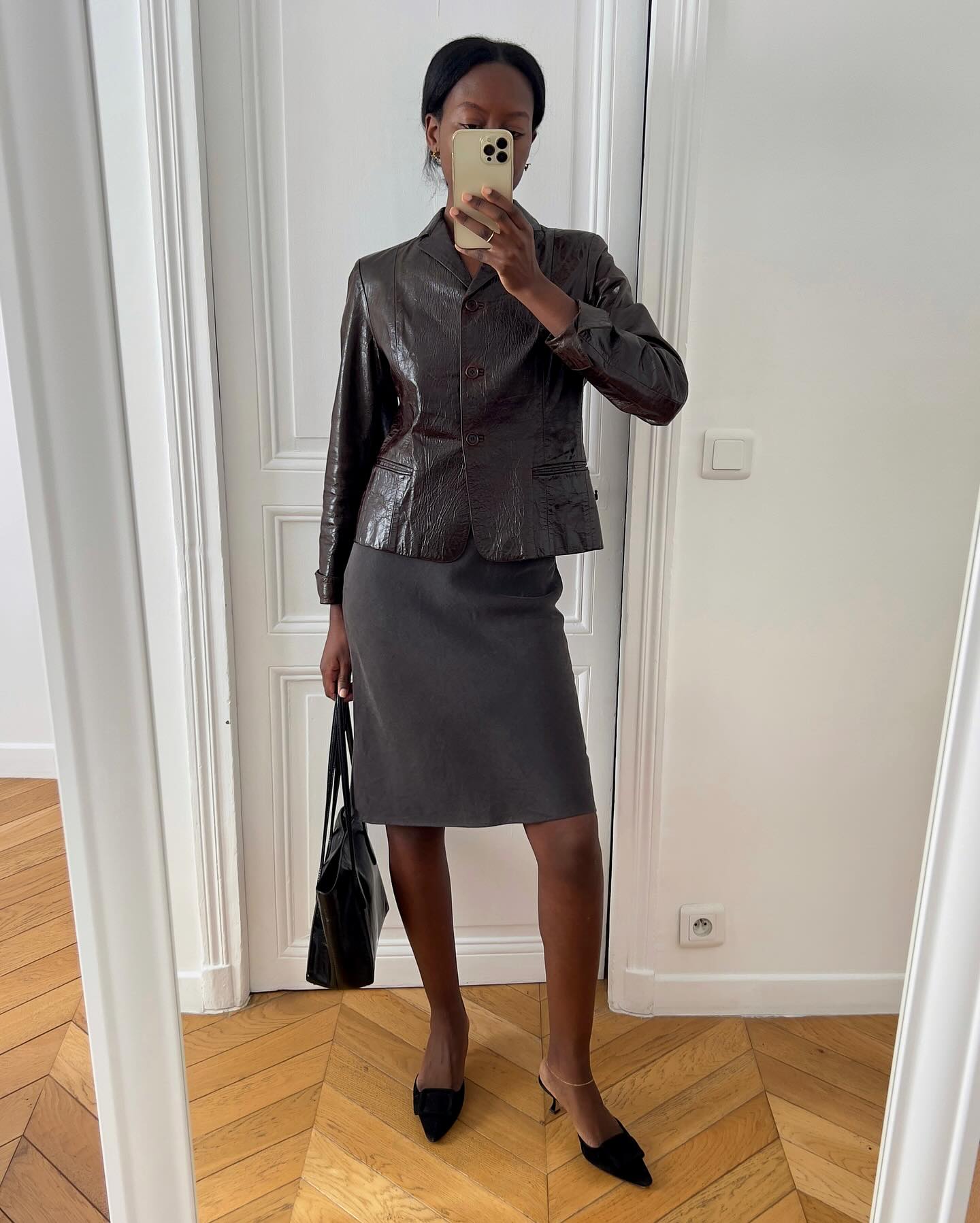 Women taking mirror selfie wearing skirt suit