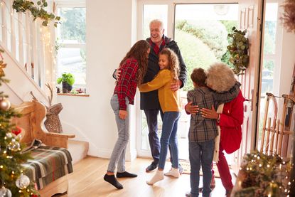 Excited Grandchildren Greeting Grandparents With Presents Visiting On Christmas Day under the new coronavirus Christmas rules UK 2020