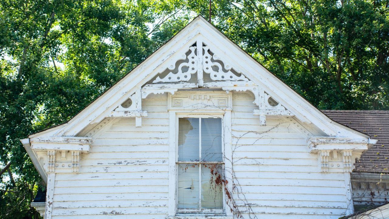 The gable field of an old Victorian-era building has a detailed vergeboard