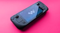 Valve Steam Deck (LCD) handheld gaming PC on a pink card background