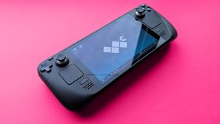 Valve Steam Deck (LCD) handheld gaming PC on a pink card background