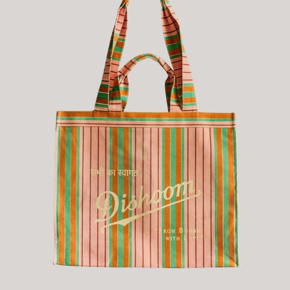 A pink, red, and orange market back with a structured silhouette and the logo "Dishoom" sits against a pale grey background.