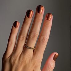 A cinnamon-coloured, glittery French tip manicure