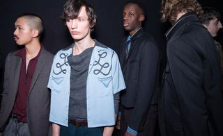 Group of models stand together in a studio preparing for show