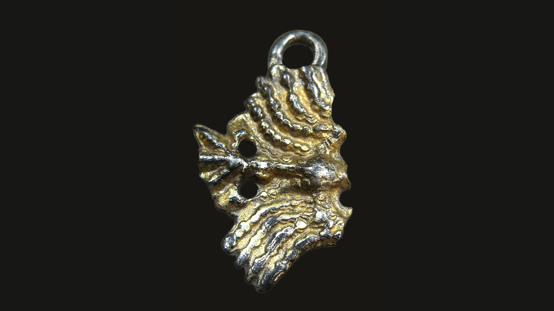 a gold pendant in the shape of a bird