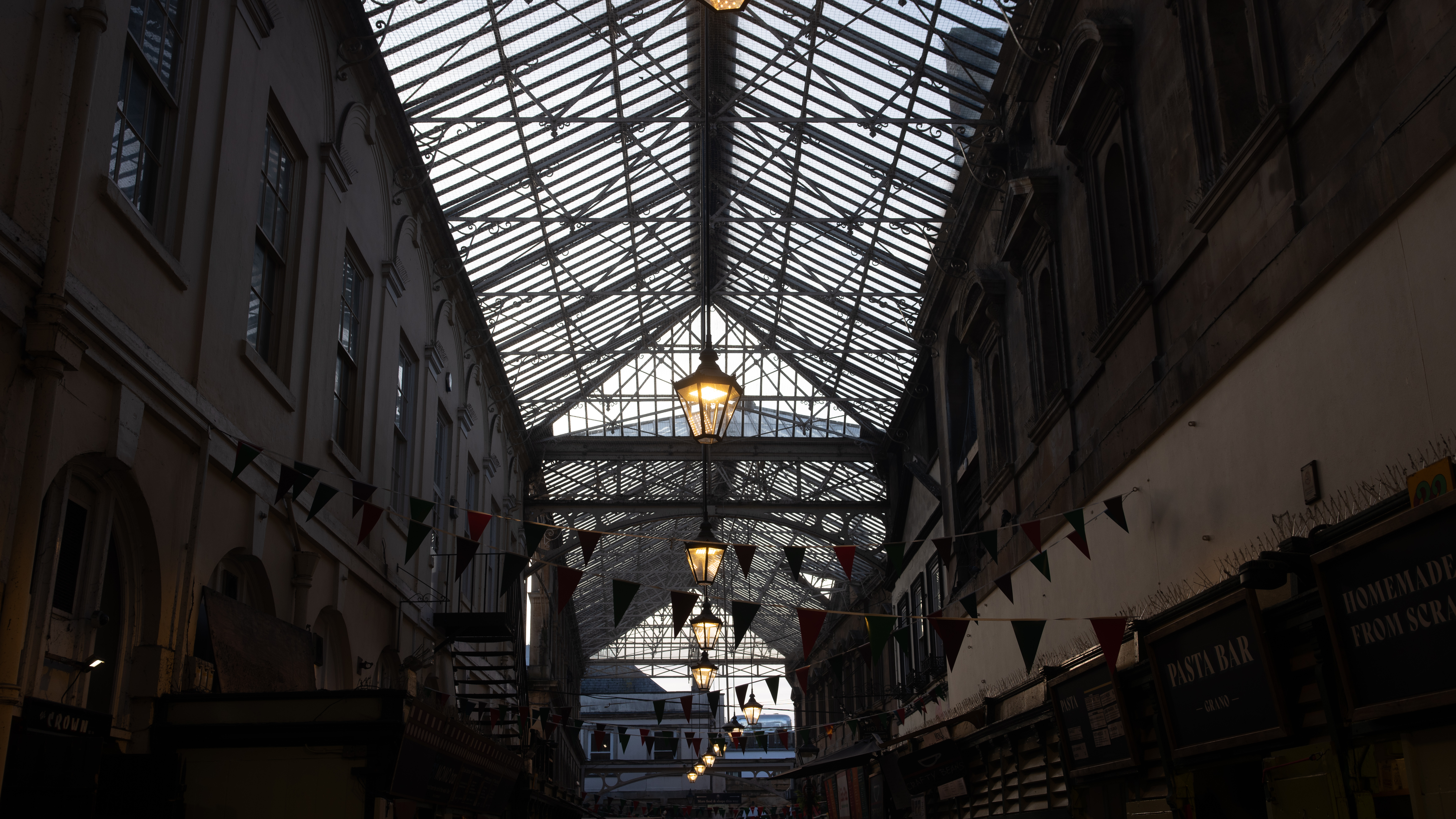 A wide-angle shot of St Nick's market in Bristol, showing market stands and the building's large central skylight.