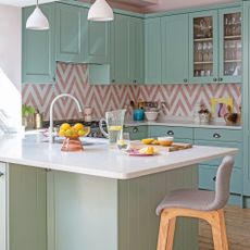Pink and green kitchen with peninsula seating