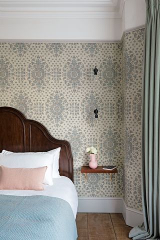 Bedroom with wallpaper and floating shelving